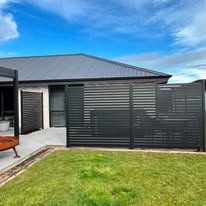 Dark slatted privacy screens beside the house